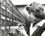 Black and white photo of a woman using the card catalog