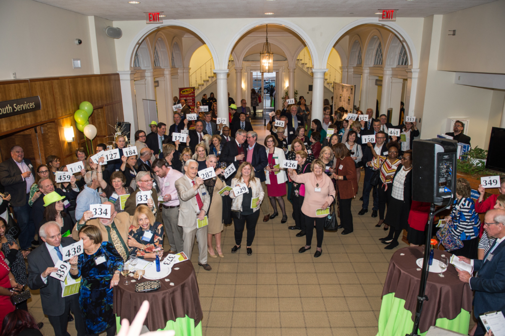 Crowd holding up auction paddles