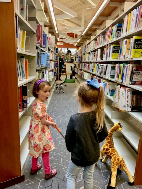 2 little girls playing mini-golf in the library