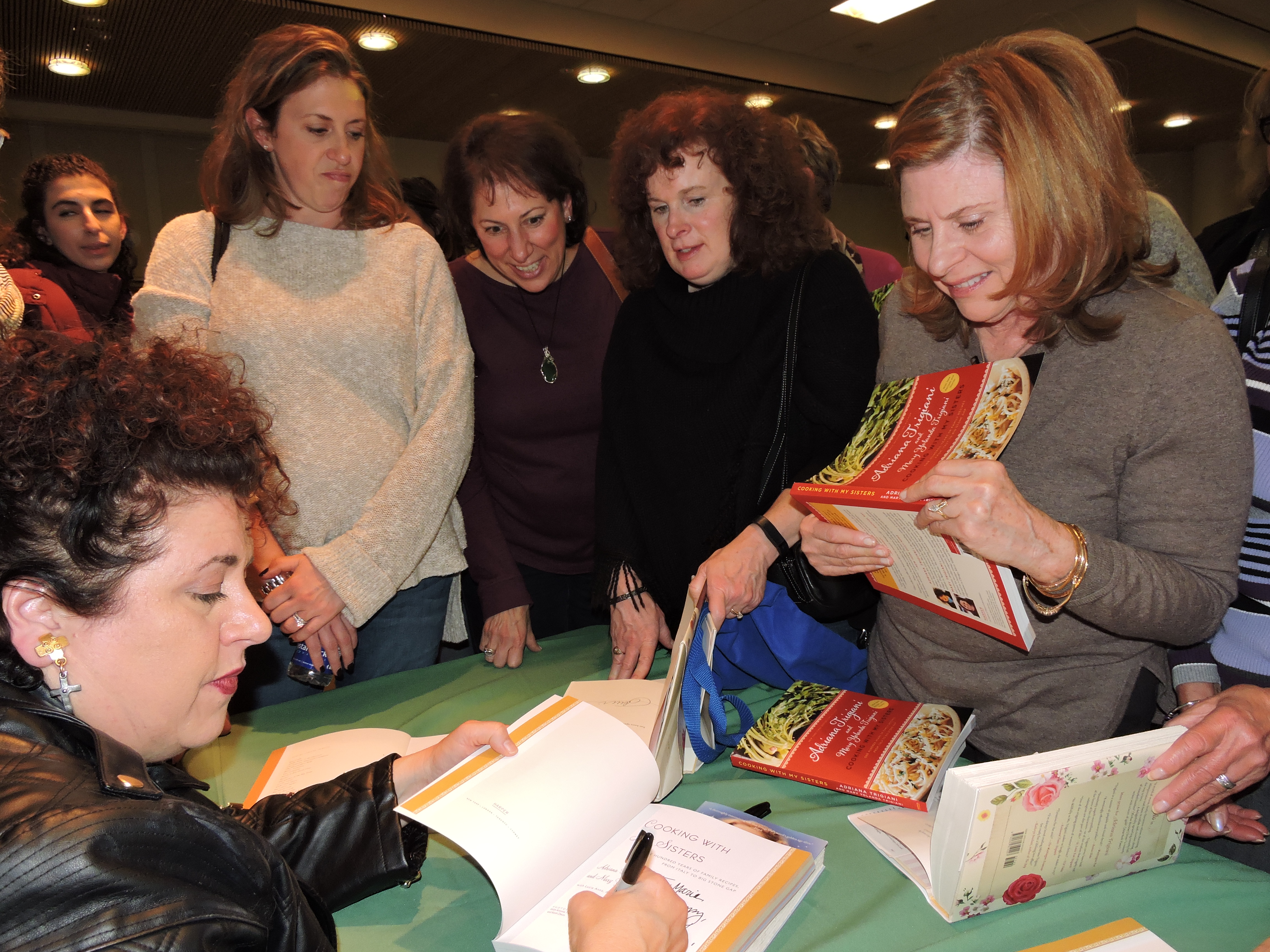 Author Adriana signing books at library event