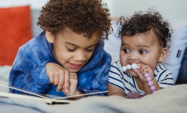 Young child reading to baby