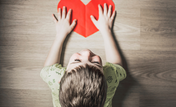 Young boy with cut-out paper heart